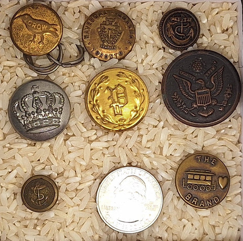 8-piece collection of antique metal military and uniform buttons featuring crown, eagle, and nautical anchor designs.